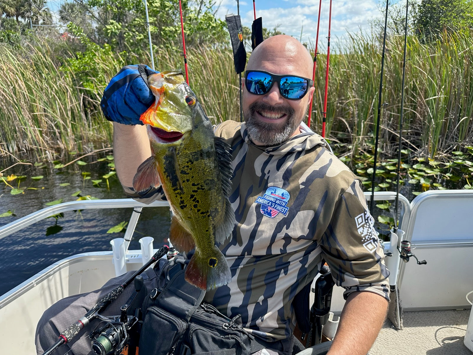 Man holding a large fish caught while fishing on a boat