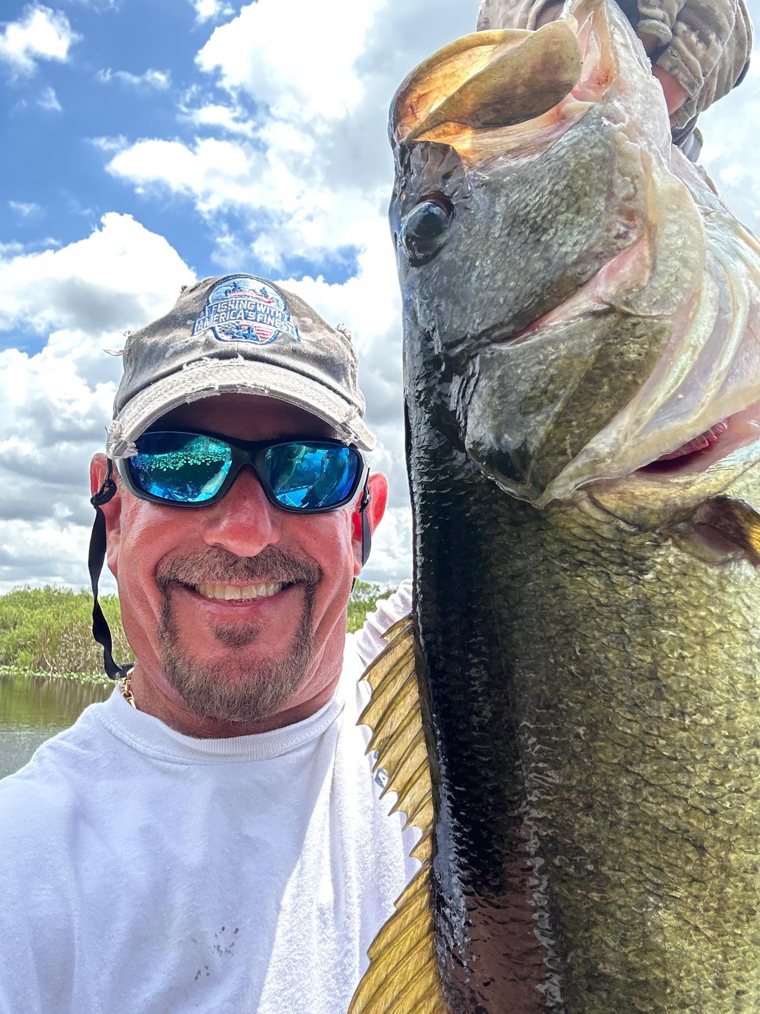Man holding a large fish with a scenic background