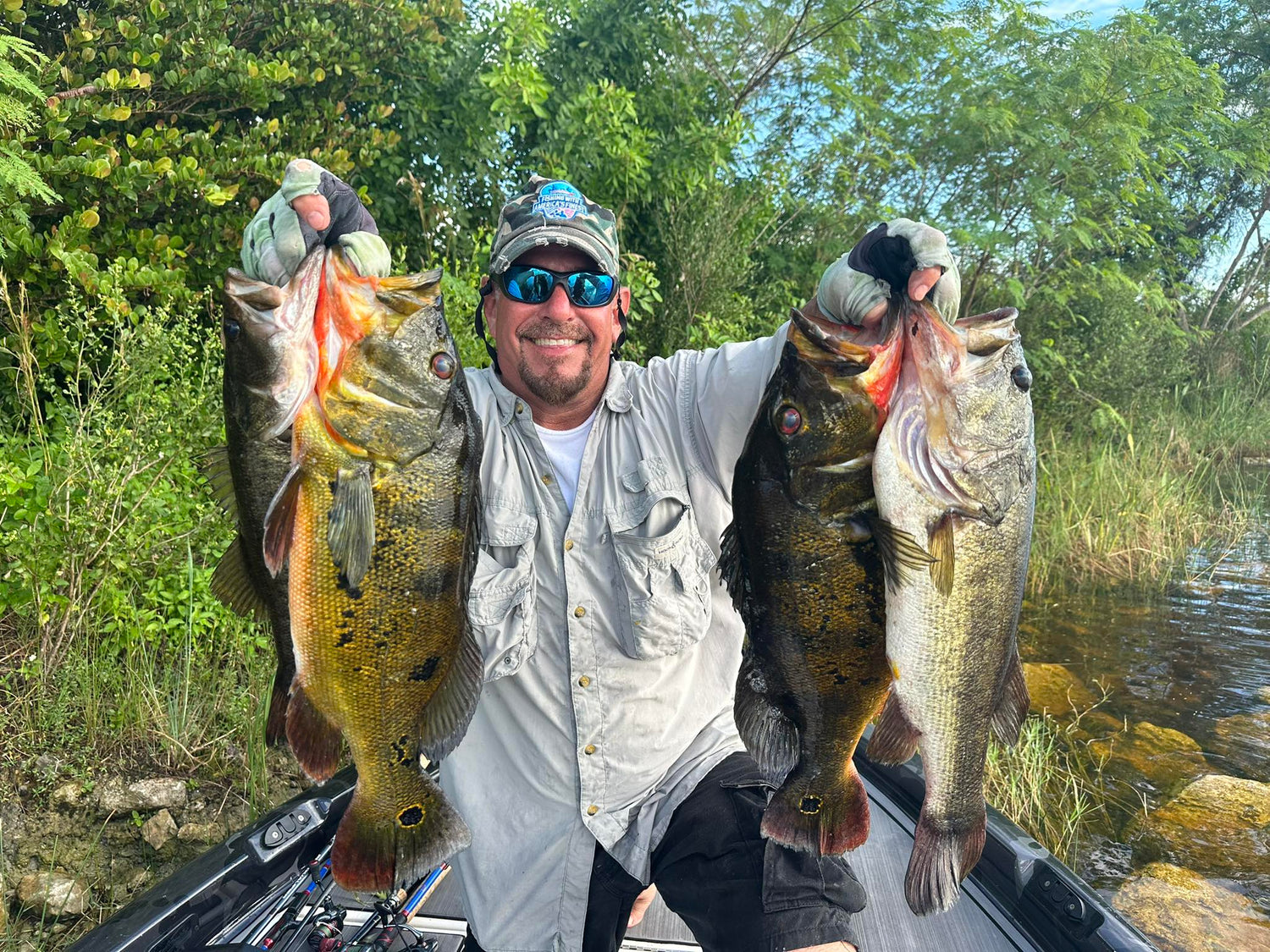 Man holding two large fish on a boat with a natural background